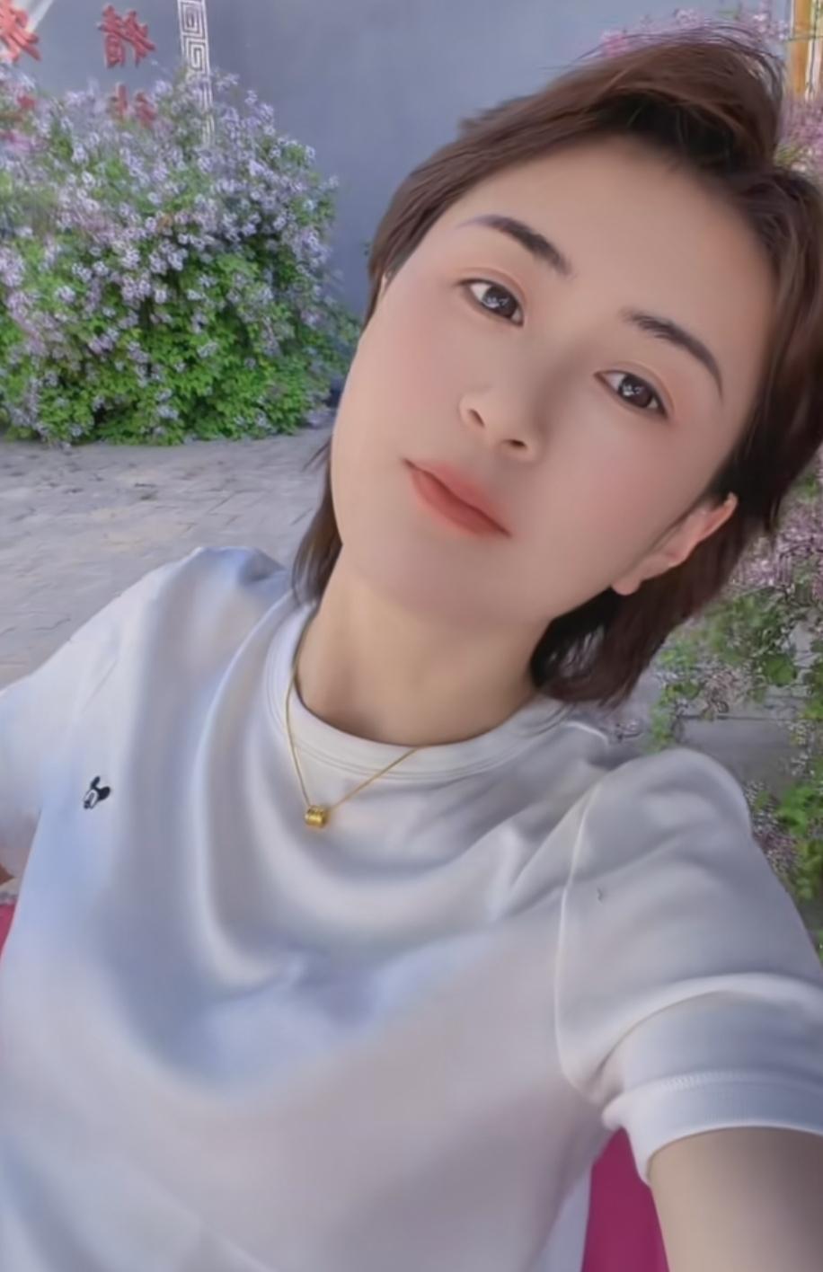 阳光下的甜美自拍，花丛中的清新气息那阳光洒在她的脸庞，勾勒出精致的轮廓，甜美的笑