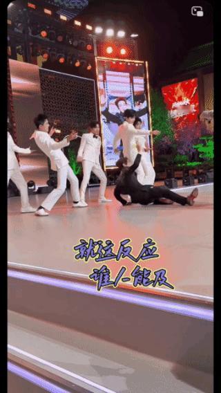 迅速救场，
小伙子反应超前！
一不小心滑倒在地，
周围伴舞惊慌失措，
但是他不慌