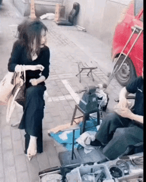 🈹我感觉女人才是老师傅，她在指点徒弟怎么操作。修鞋是她的专业领域。
