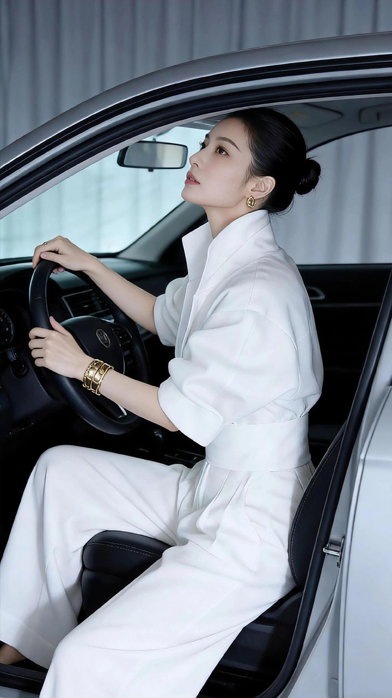 白衫与车影
 
冷调的影棚里，金属与织物的碰撞生出利落的韵致。一袭纯白连体西装裹