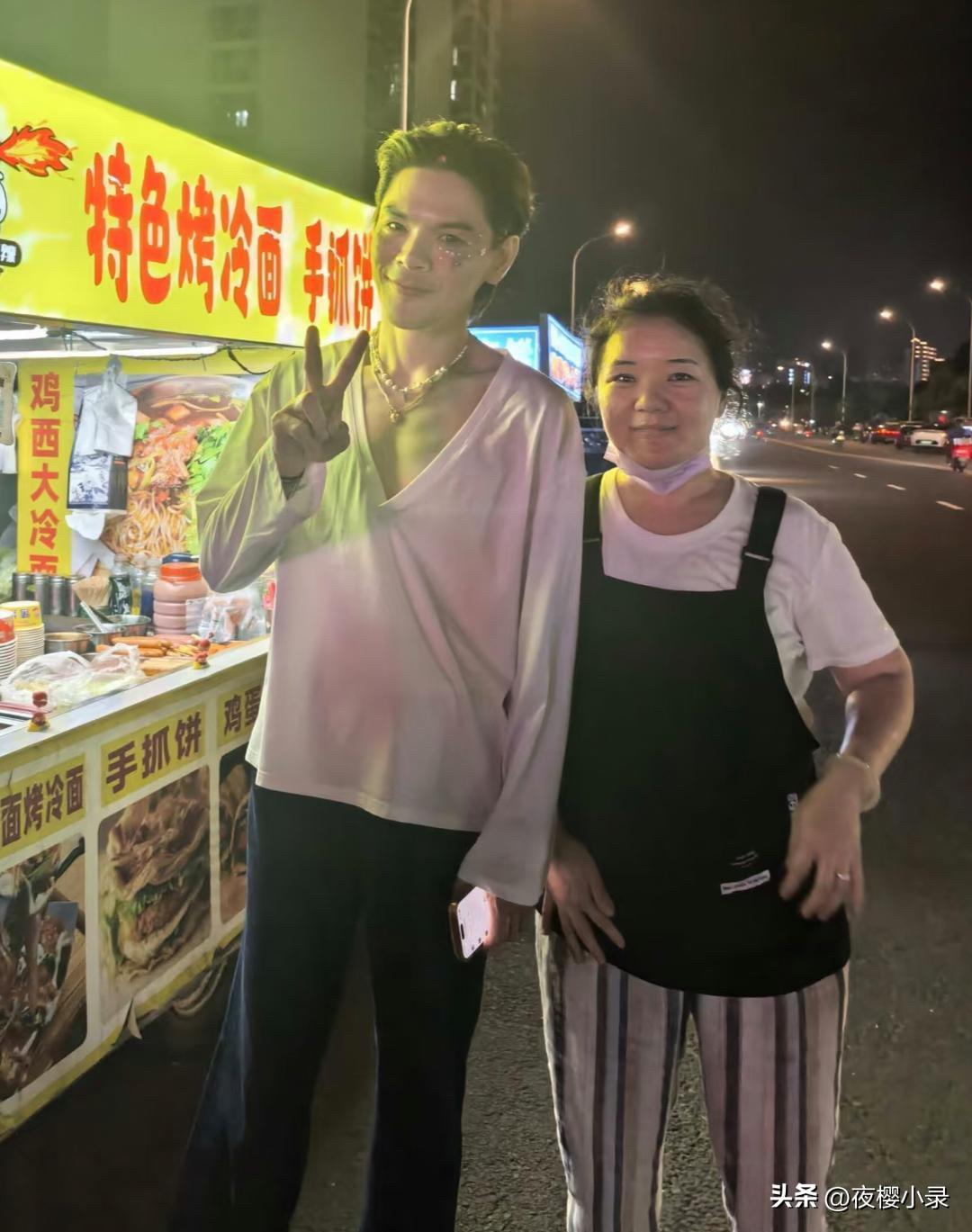 42岁向佐在海南三亚夜市路边摊买烤冷面，他脸上化着精致的妆容，戴着珠宝首饰，像个