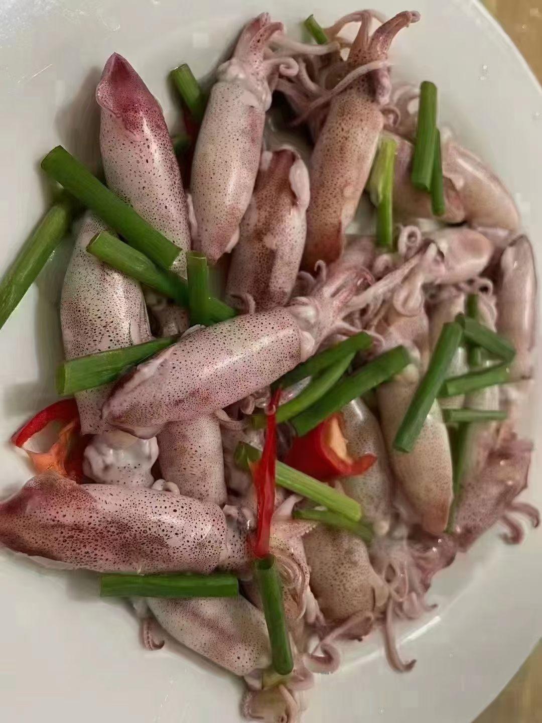 一盘章鱼配上葱段和红椒。