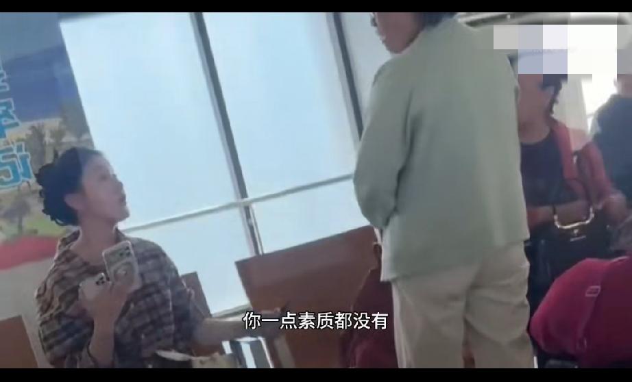 候车室里一名年轻女子占座，用行李、饮品依次摆放，霸占多个空余座位。年长的大姐想要