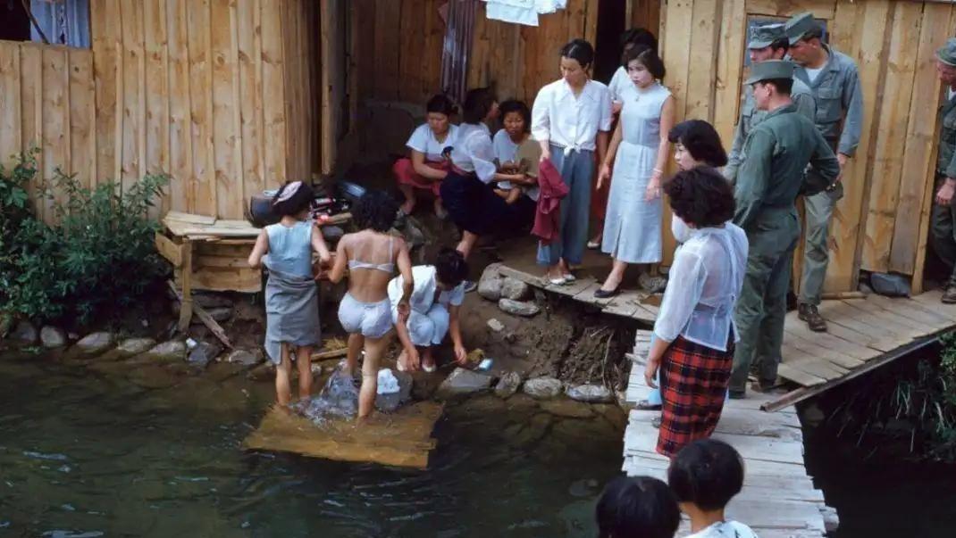 晒出相册中的老照片上世纪五十年代的韩国，几个驻韩美军士兵，在饶有兴趣的看着韩国女