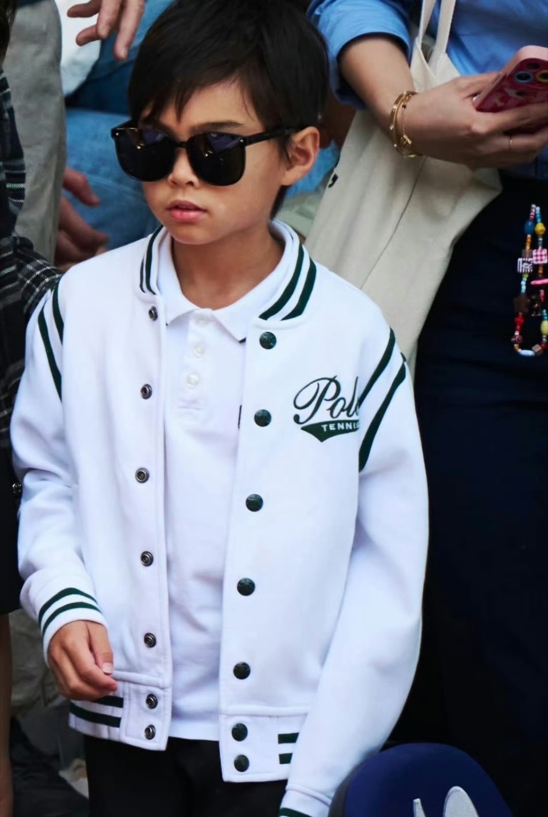 周杰伦昆凌带儿子现身网球赛场，小朋友颜值不错。同款黑超墨镜一戴，小脸绷着的拽酷劲