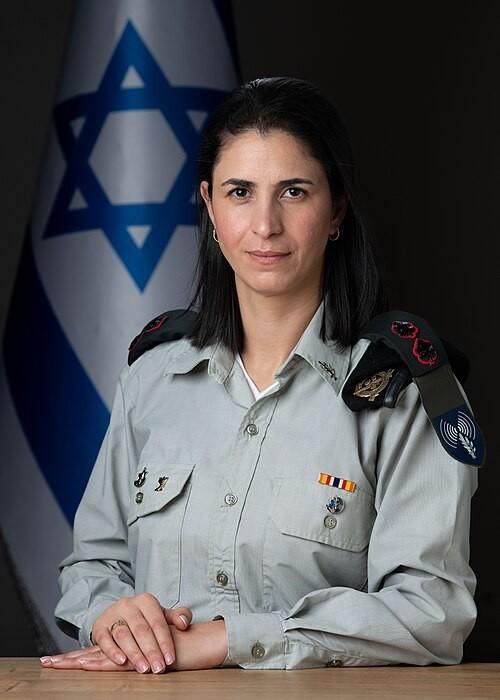一个穆斯林家庭出身的女人，穿着以色列军装，站在特拉维夫的交接仪式上。
表情严肃。