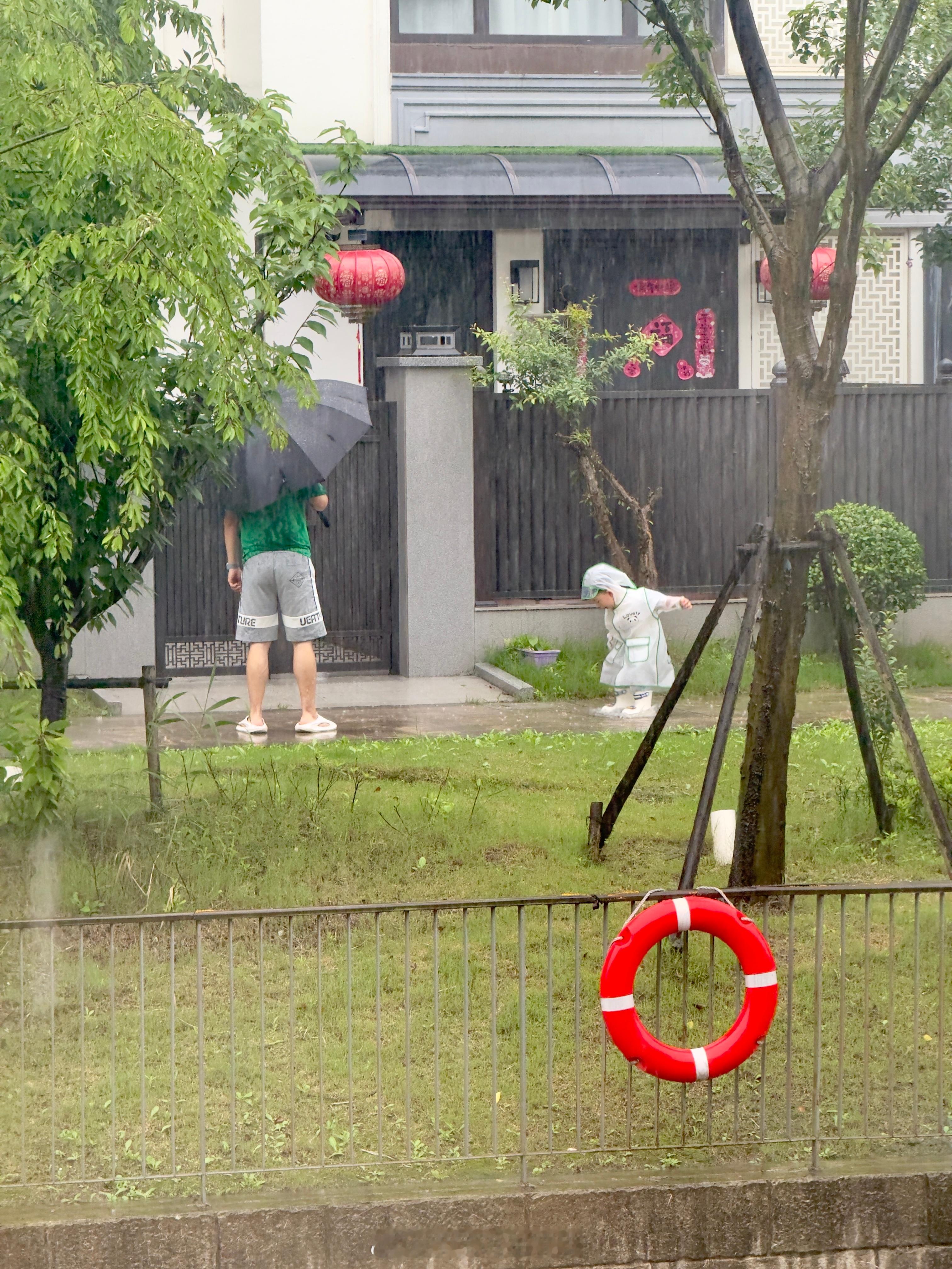 今天上海大雨。看到一位父亲带着孩子在雨中玩水。看得出孩子特别开心。这一定是一位好