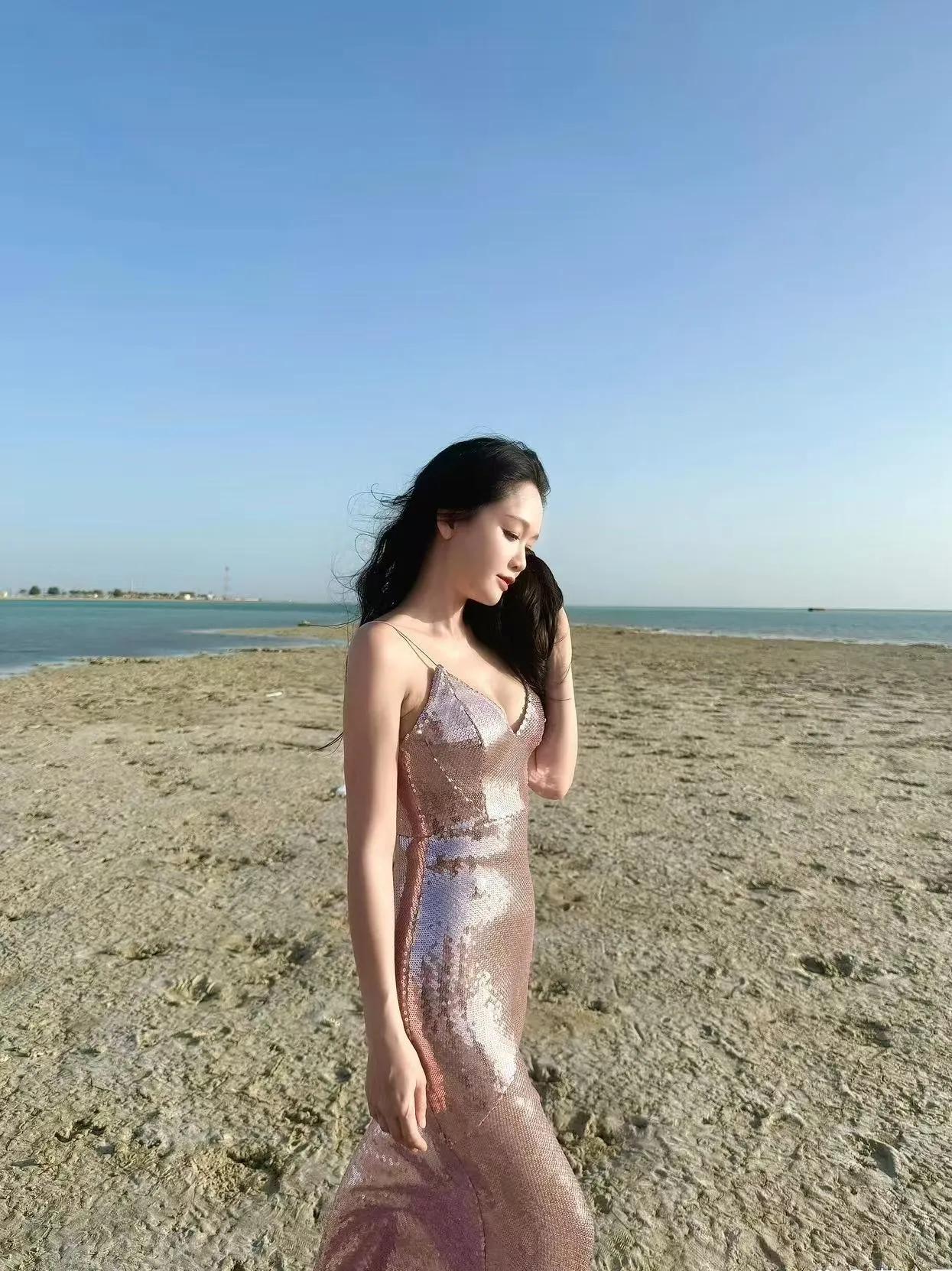陈乔恩海边粉亮片长裙太绝了✨
细吊带V领鱼尾裙铺满渐变粉亮片，阳光下波光闪闪
修