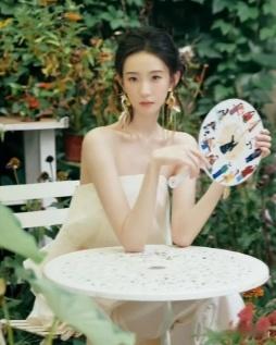 爆出的张艺凡美照太惊艳了！照片里她身着抹胸白裙，盘起头发，手持圆扇，气质优雅得没