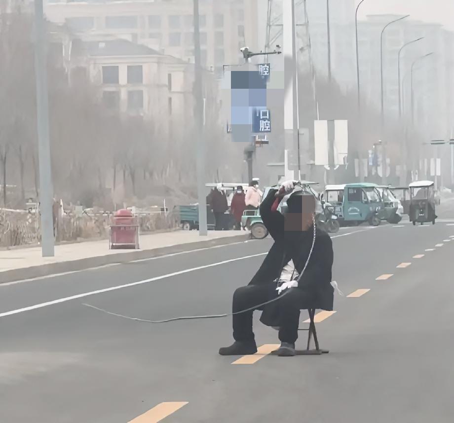 一般人可真不敢这么干！
寿光市某地马路上，一老头拿着鞭子坐在马路中央，哪个车过去