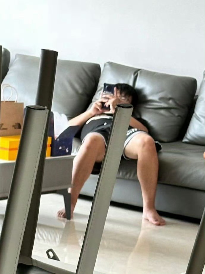 保洁阿姨的儿子坐在沙发上 