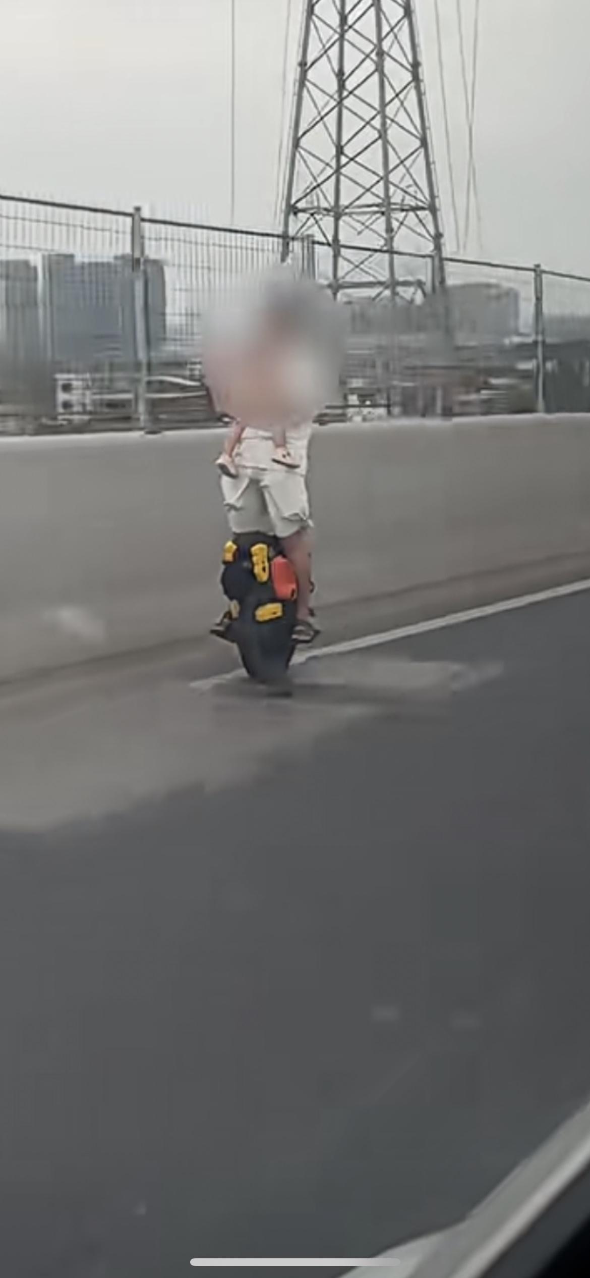 近日，广州沙湾大桥上，有网友拍到一名男子手抱婴儿，脚踩平衡车在车流旁高速穿行。一