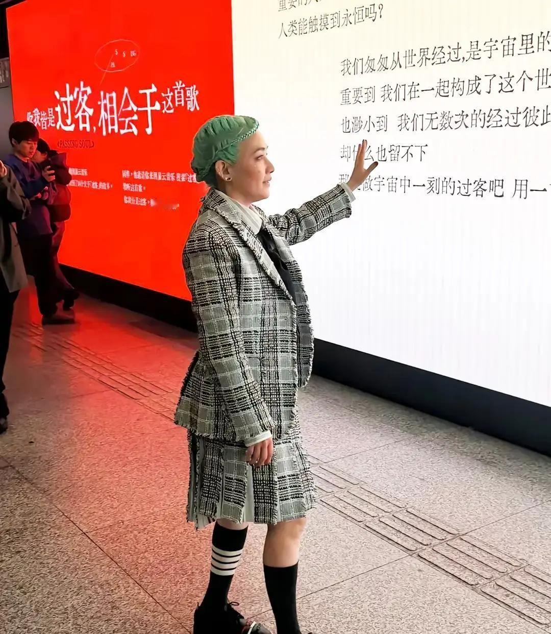 范晓萱顶着一头翠绿短发、画着大烟熏妆出现在上海地铁站，48岁的人走在人群里比信号