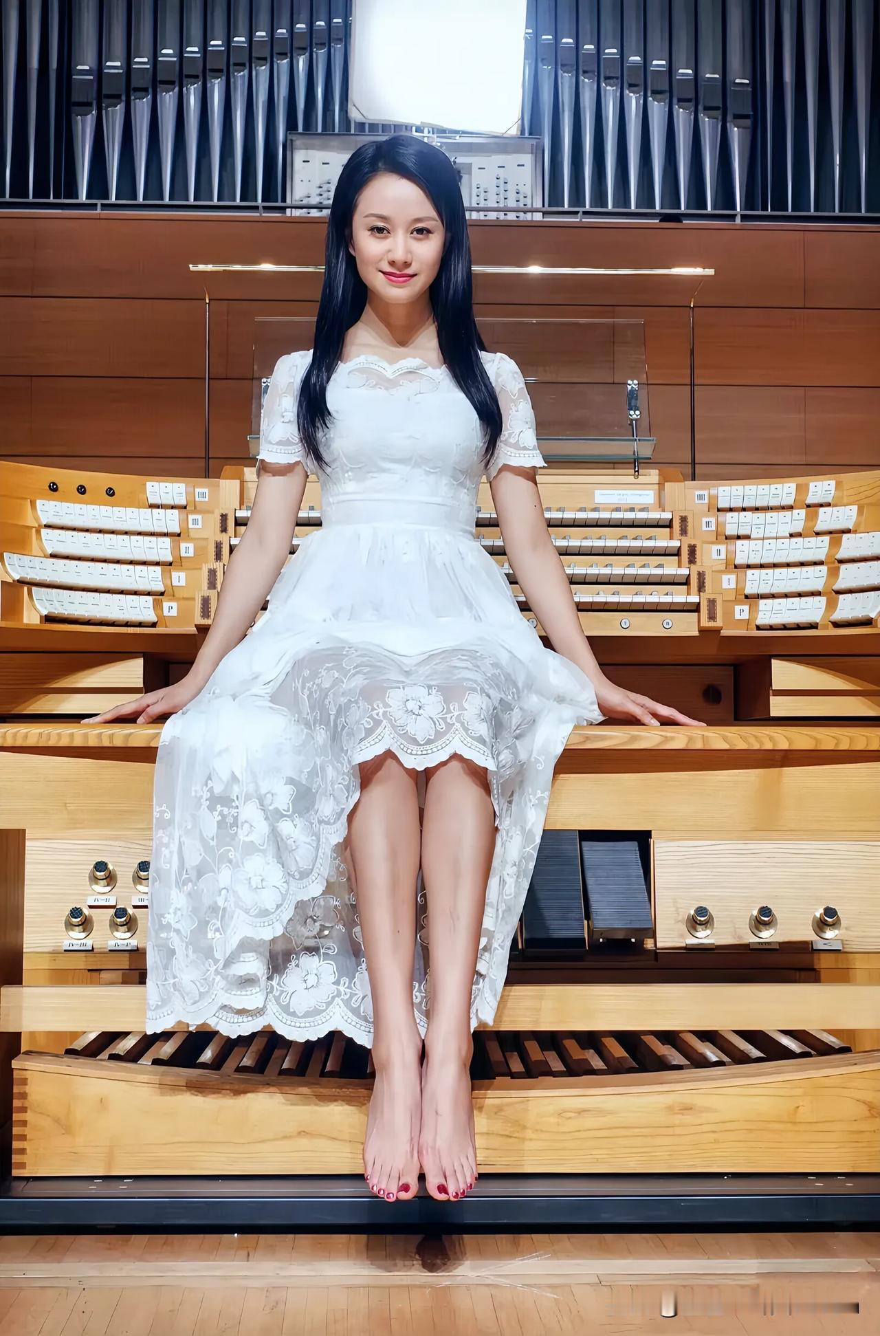 在华丽的管风琴前，倪虹洁身着一袭纯白蕾丝裙，优雅落座。长发自然垂落，衬得脸庞愈发