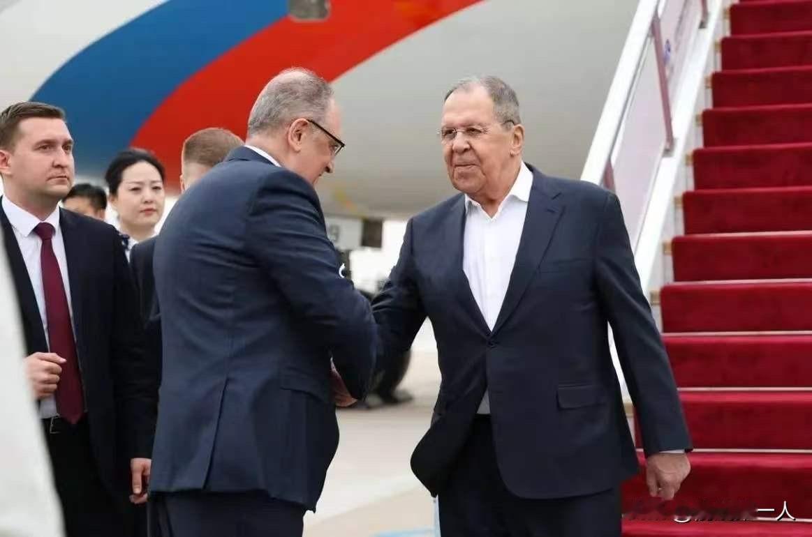 76岁的外长，下飞机握完手，转身从后裤袋掏出手机。
不是助理递的。
不是西装内袋