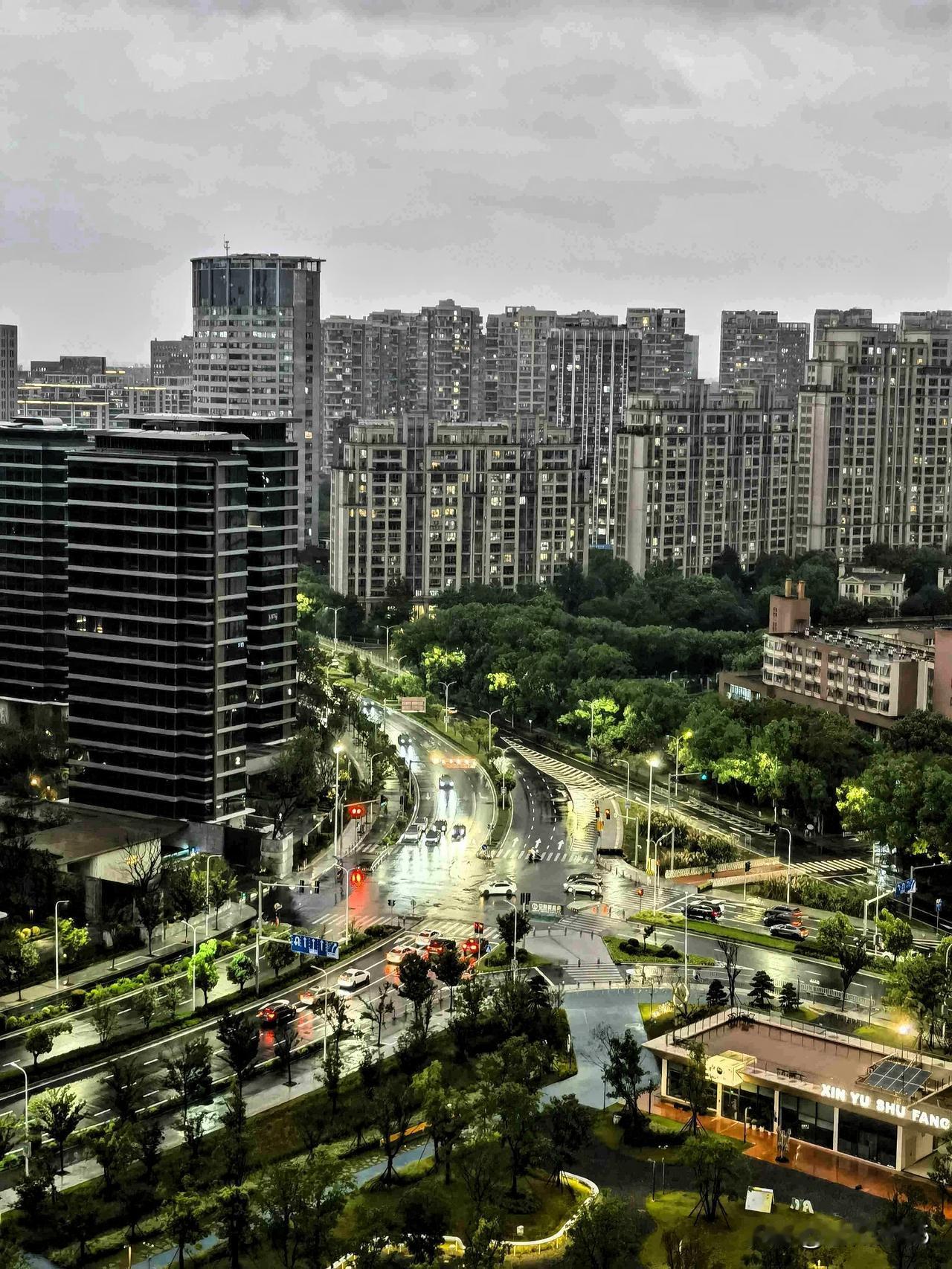 雨水初歇，城市的霓虹在湿润的路面上晕染开来。

车灯如流萤，高楼灯火渐次点亮，冷