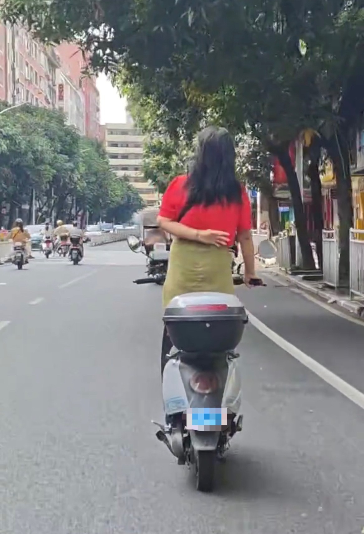【玉林一阿姨单手抓手把站电动车上骑车】7月1日，网友爆料称：玉林市城区街头一阿姨
