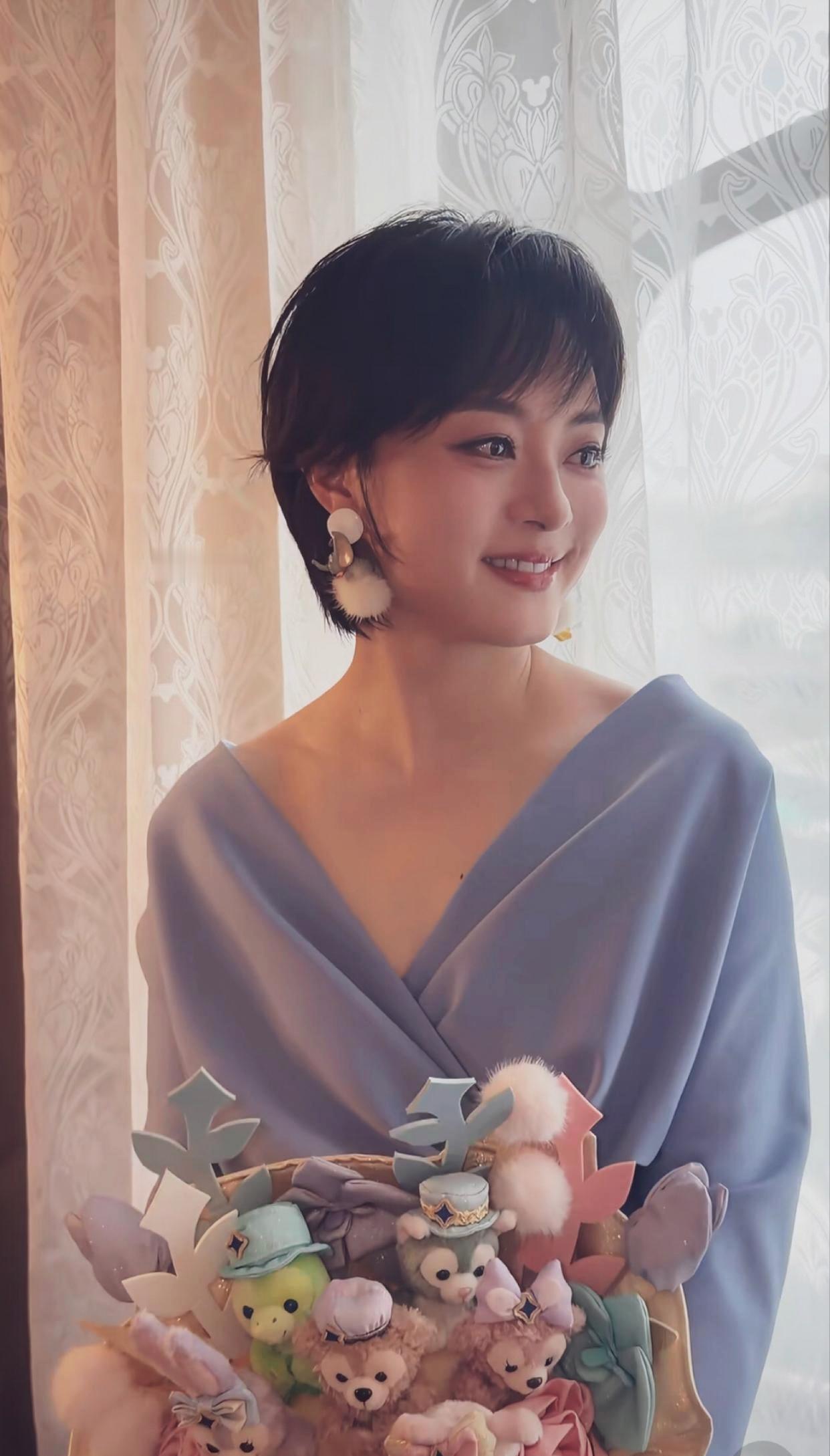 孙俪柔雾灰蓝色V领缎面长裙，温婉大气，少女般俏皮灵动。气色温润如玉，眼神清澈，少