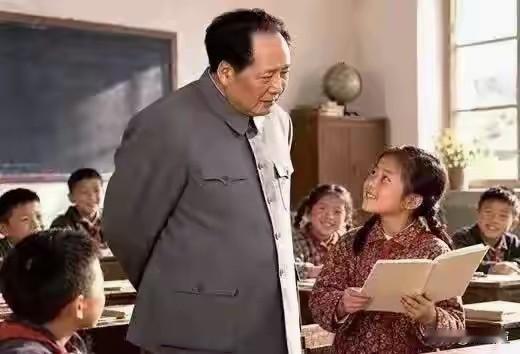 教室里，毛主席背着手，和蔼地向小女孩问话。小姑娘捧着书本，面带微笑，坦然望着主席