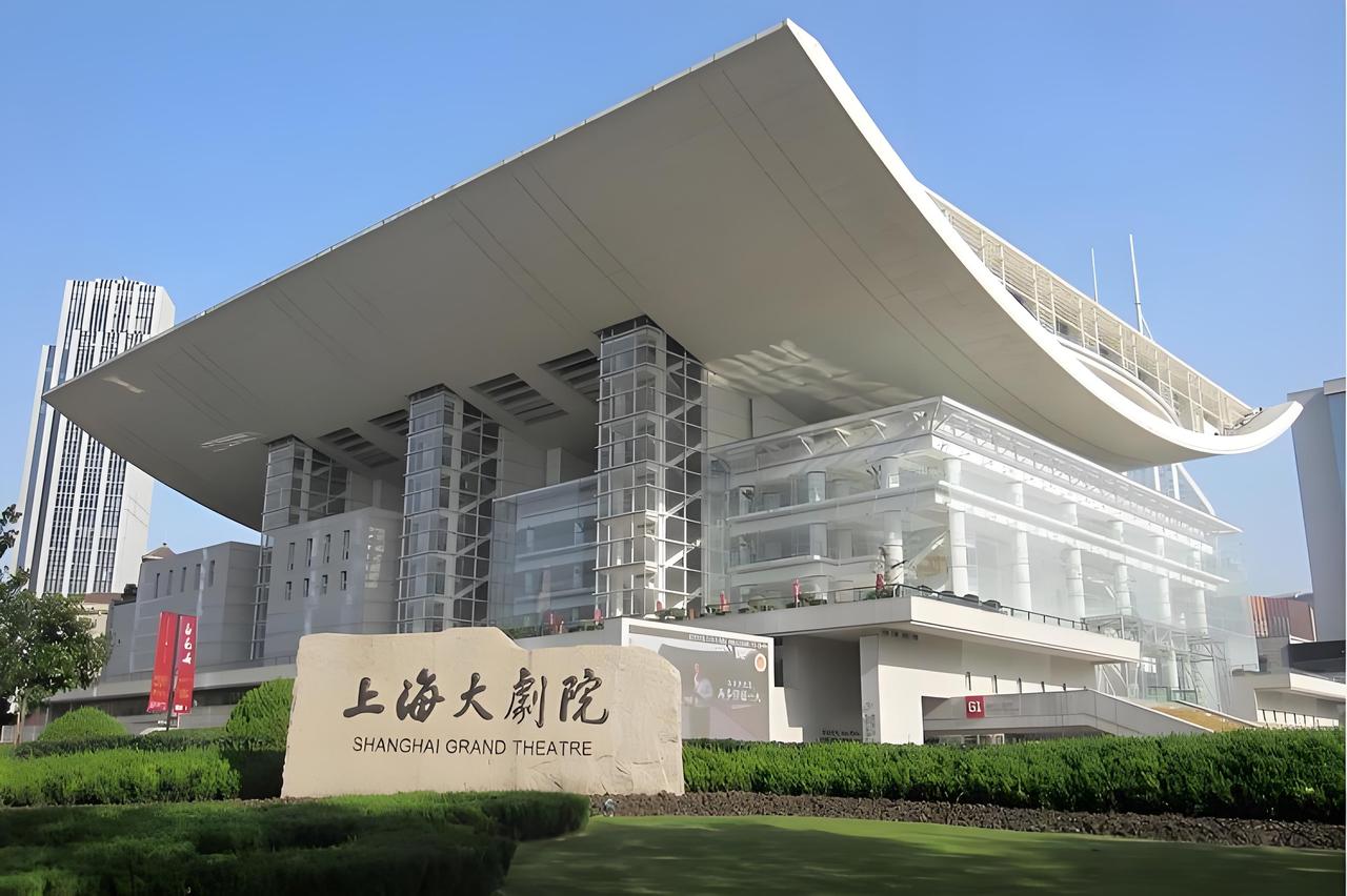 上海，一女子去剧院看歌剧，现场乐队开始演奏了，身边的大妈还在和朋友说话，女子就“
