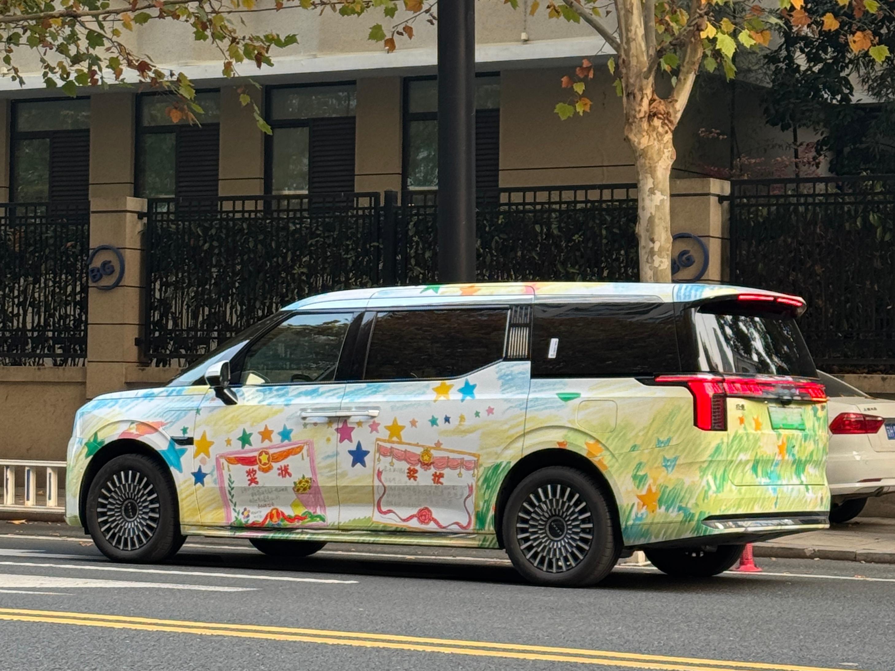 杭州街头，一辆贴满手绘奖状的极氪009 格外吸睛。与常见的动漫主题“痛车”不同，