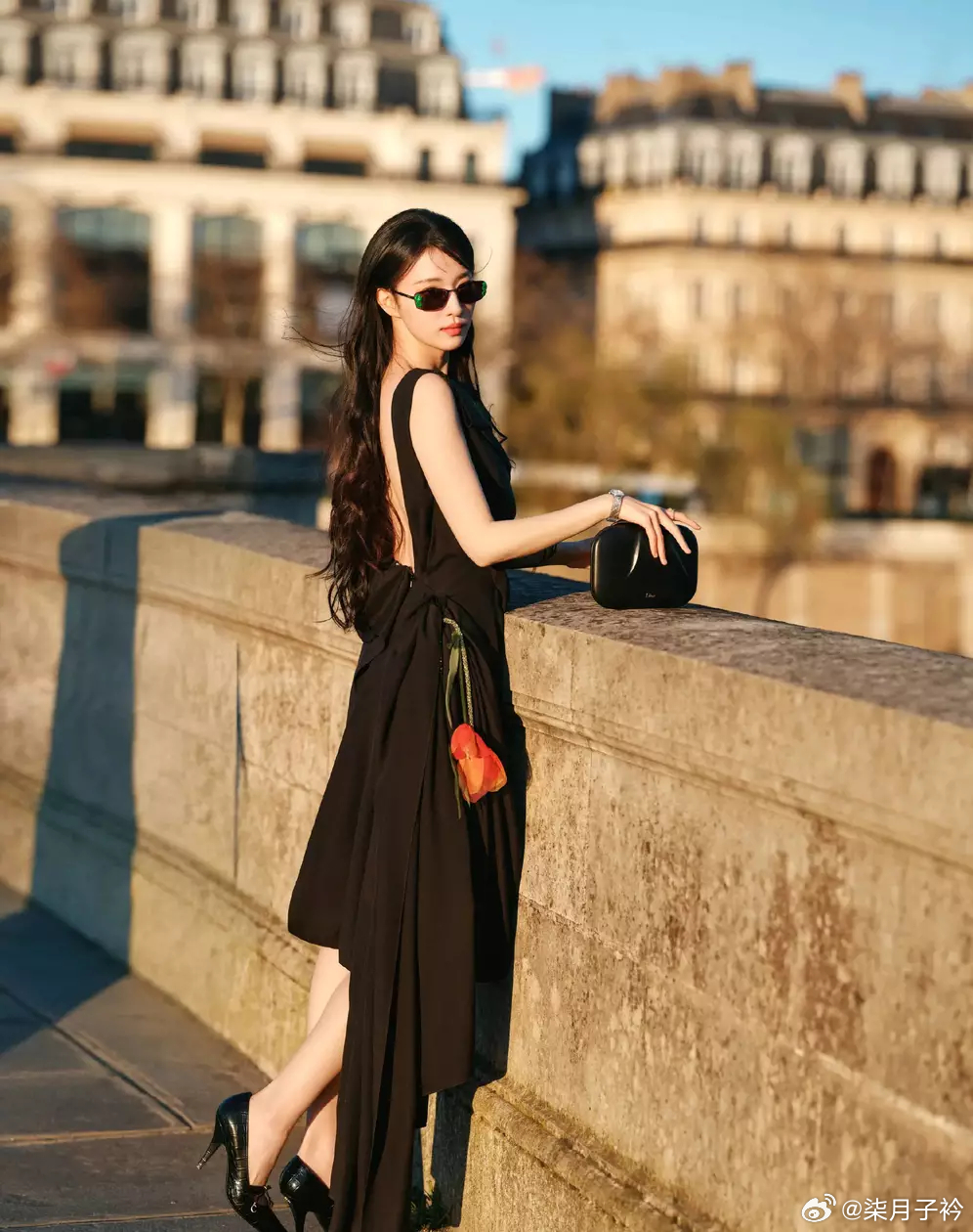 王楚然穿黑色立体花饰露背裙 在桥边漫步裙摆轻扬 