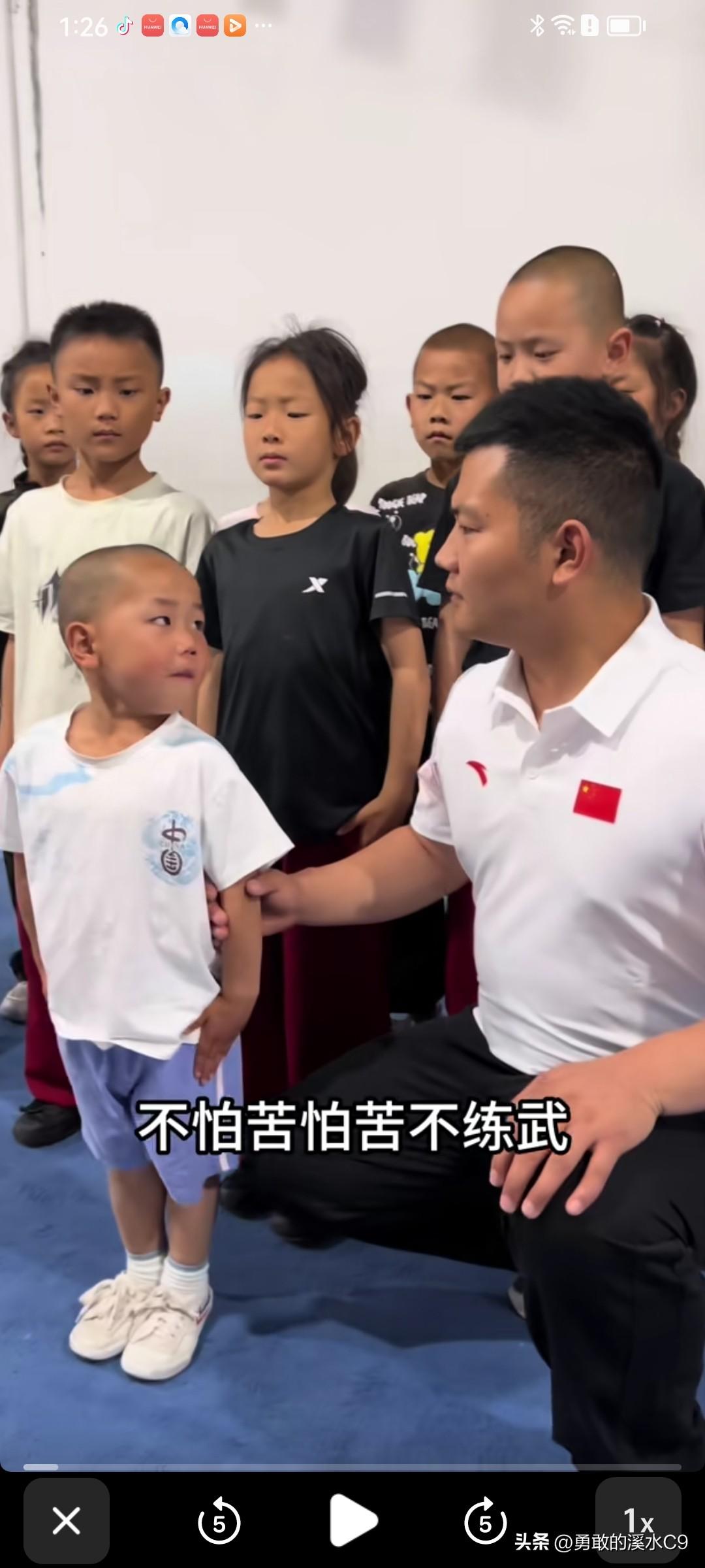 武术教练坐在场边，四岁的蛋蛋说：“我不怕苦，怕苦不练武。”教练被蛋蛋的练武精神打