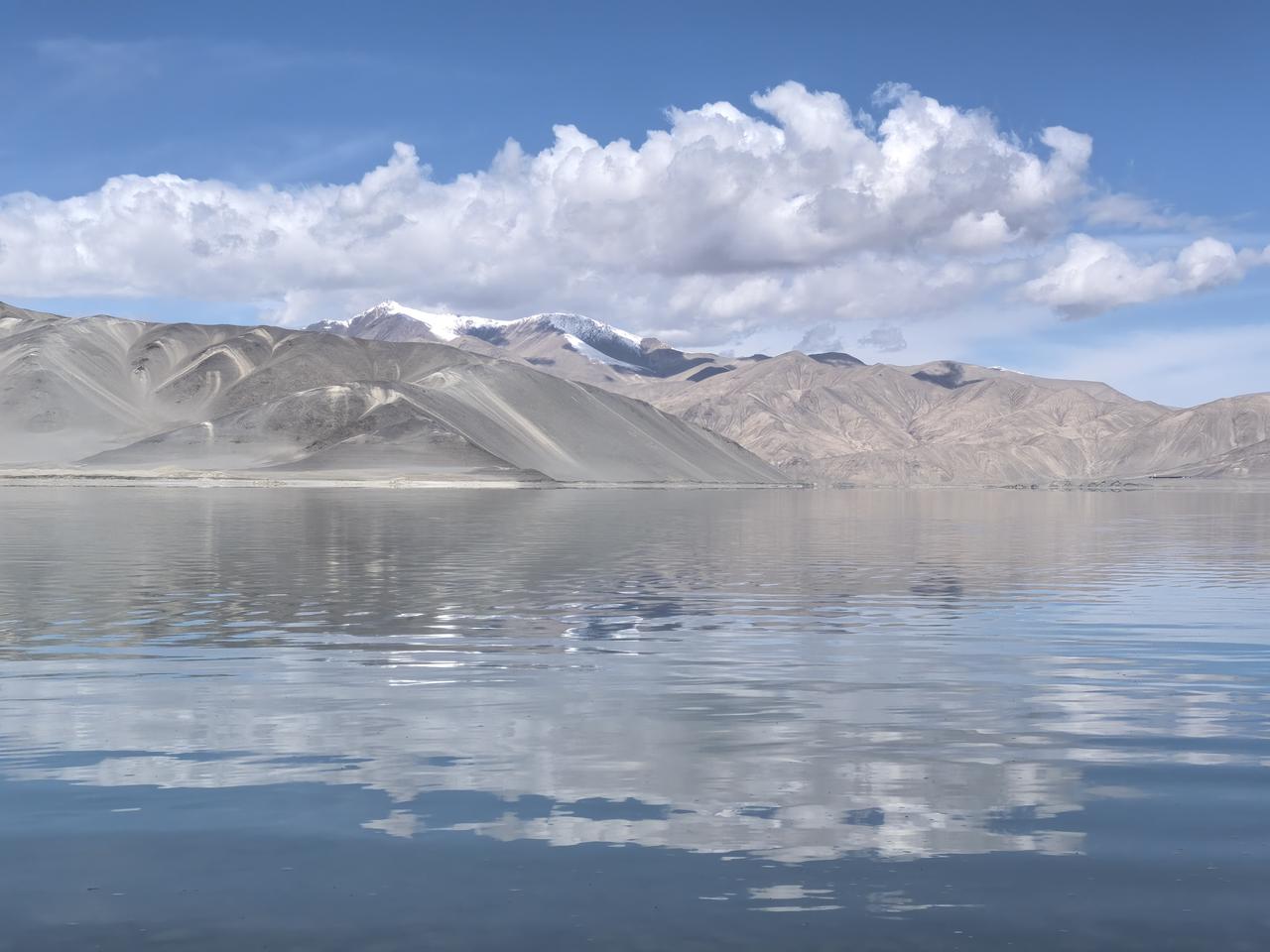 这是白沙湖的一张风景照片，白沙景点 白沙铺岸，如雪似银，在阳光下泛着细碎的光。湖