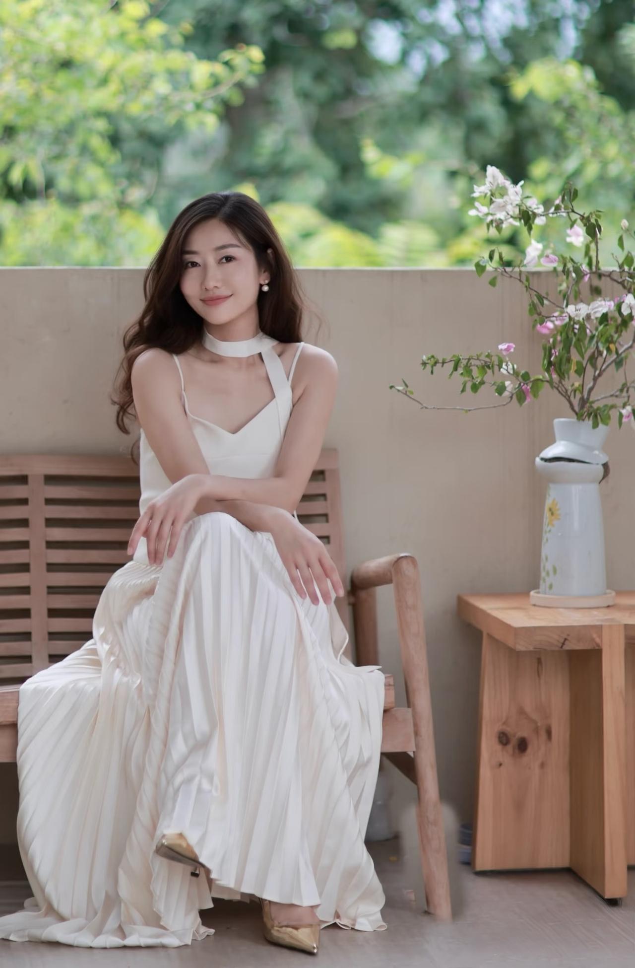 什么样的穿搭可以成为气质女神?一条白色的吊带长裙，令美女显得非常清新优雅有气质。