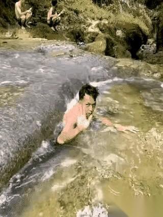 山泉水冰冷刺骨，那块黑色大岩石像个沉默的怪兽，横在深潭中间。
他指着岩石底部那道
