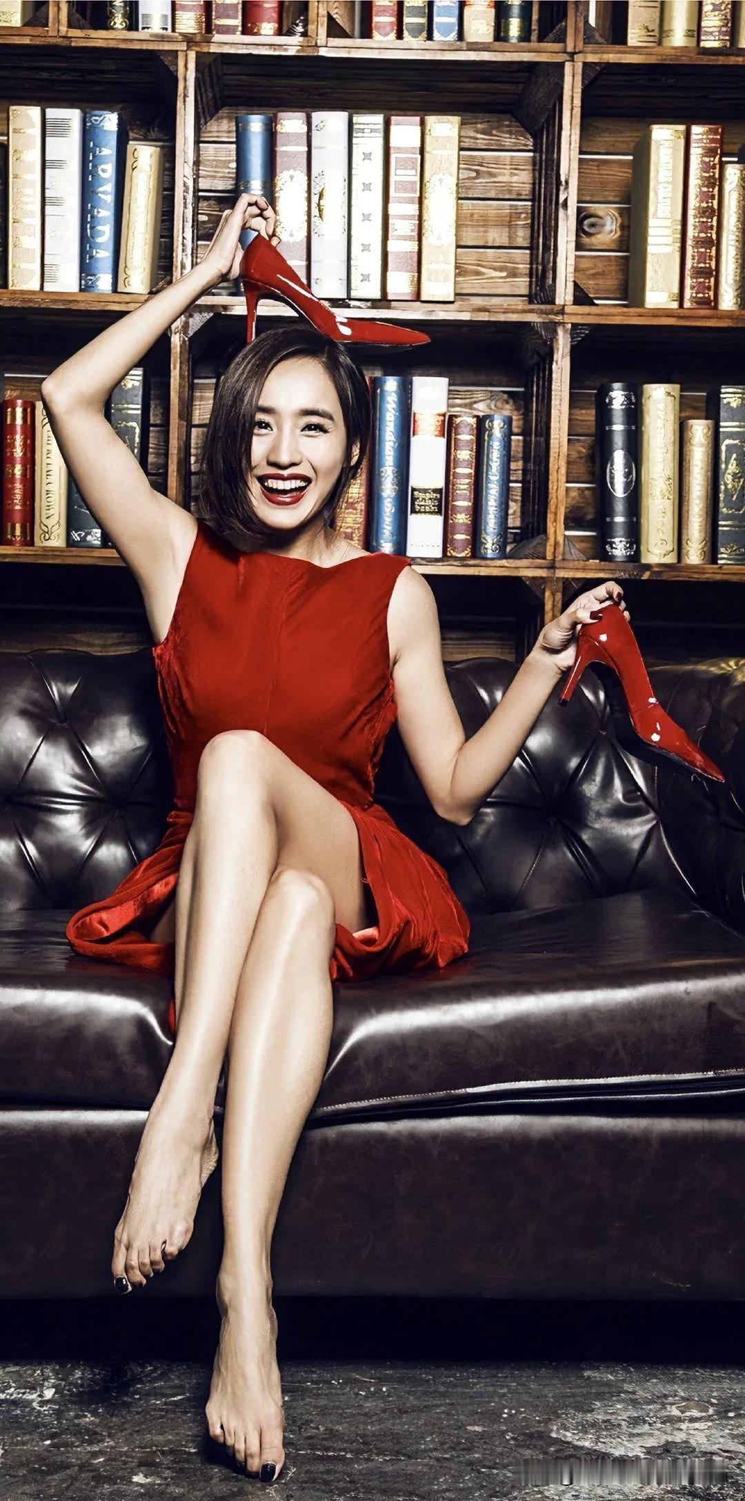 在满是故事的书架前，王智一袭红裙明艳夺目，恰似跃动的火焰，随意抛开高跟鞋，自在地