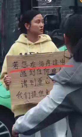 四川成都，华西医院门口有一个女孩子胸前举着一块牌子，写着提供免费住宿吃饭，很多人