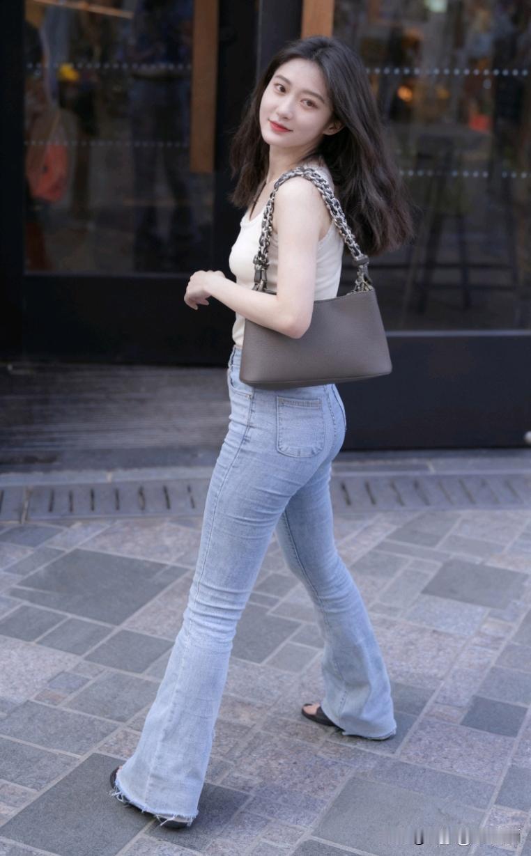 都市街头就是时尚少女的秀场。瞧那自信漫步的女孩，身着露肩短裙，阳光洒在她光滑的肩