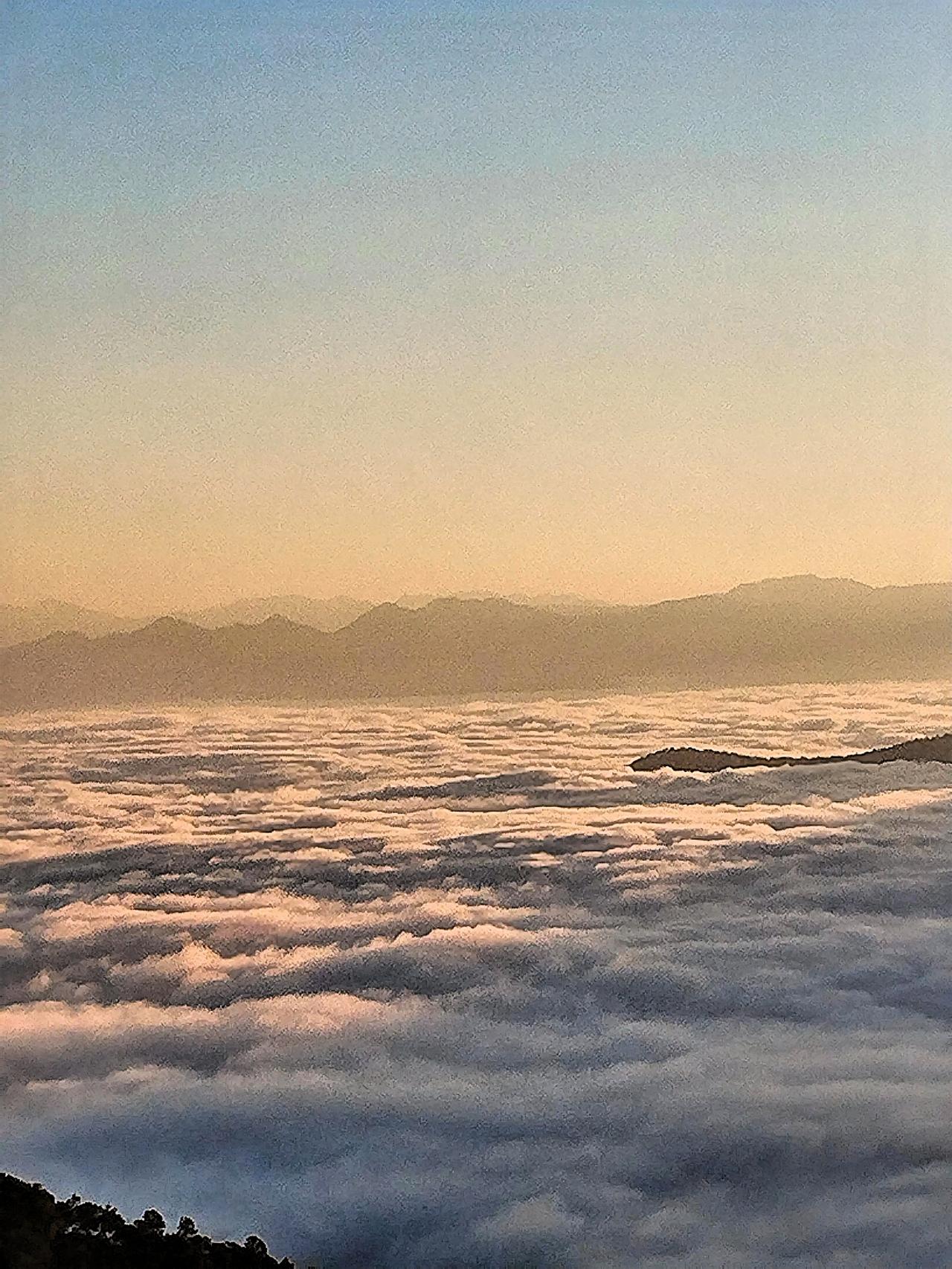 云海汹涌翻腾，山峦隐隐约约，好似置身于缥缈仙境。云里雾里，光彩四溢。
这般如梦似