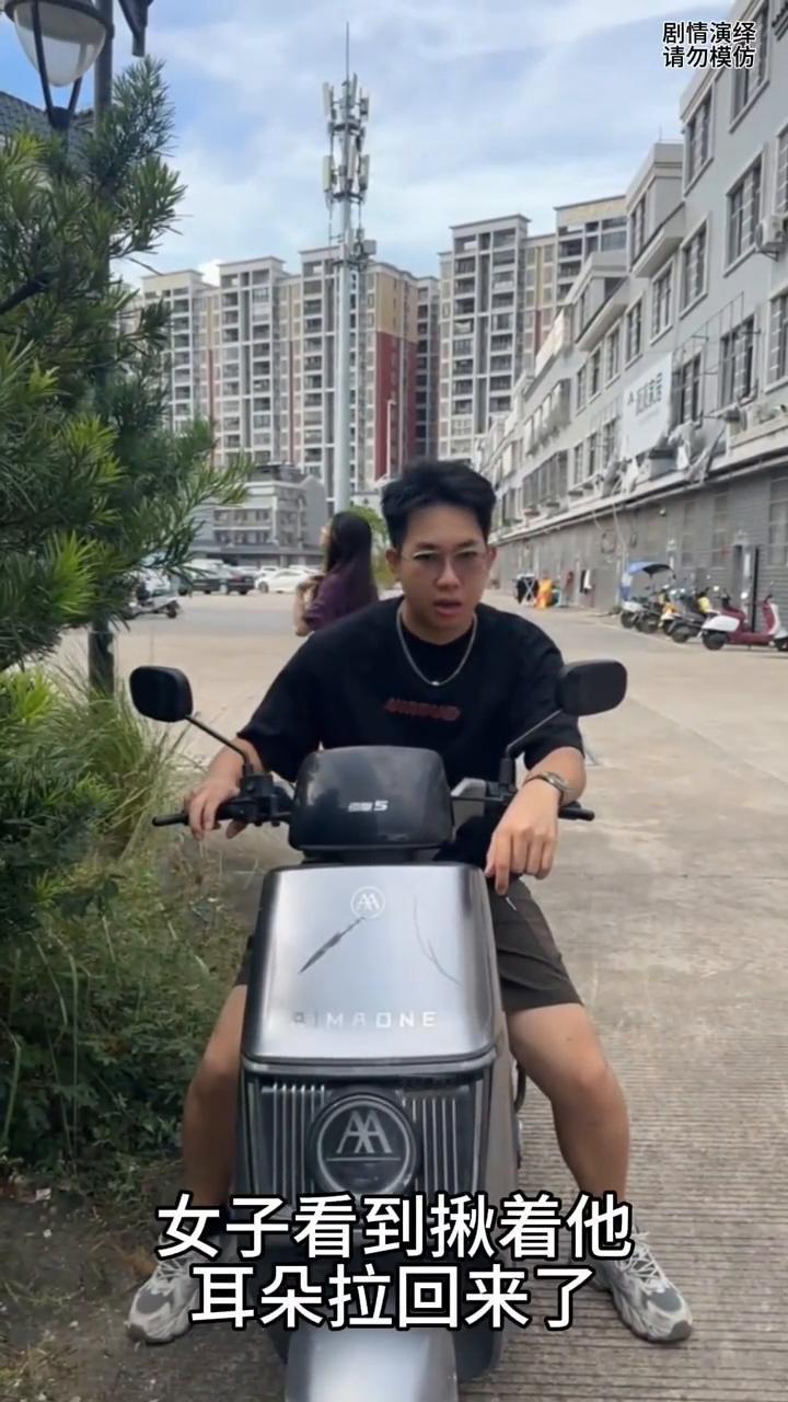 男子坐电车上想事情，突然他的电车往一边翻倒，女子看到揪着他耳朵拉回来了，此刻男子