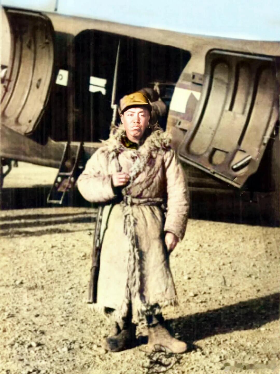 士兵站在美国飞机前，身上裹着从老乡家借来的羊皮大氅，负责警戒工作！天寒地冻，条件
