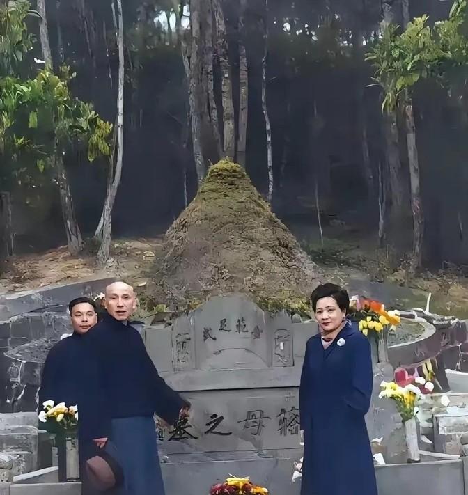 左边穿长衫的男人刚在祖宗坟前磕完响头，裤腿还沾着浙江奉化山间的黄泥。
他起身时突