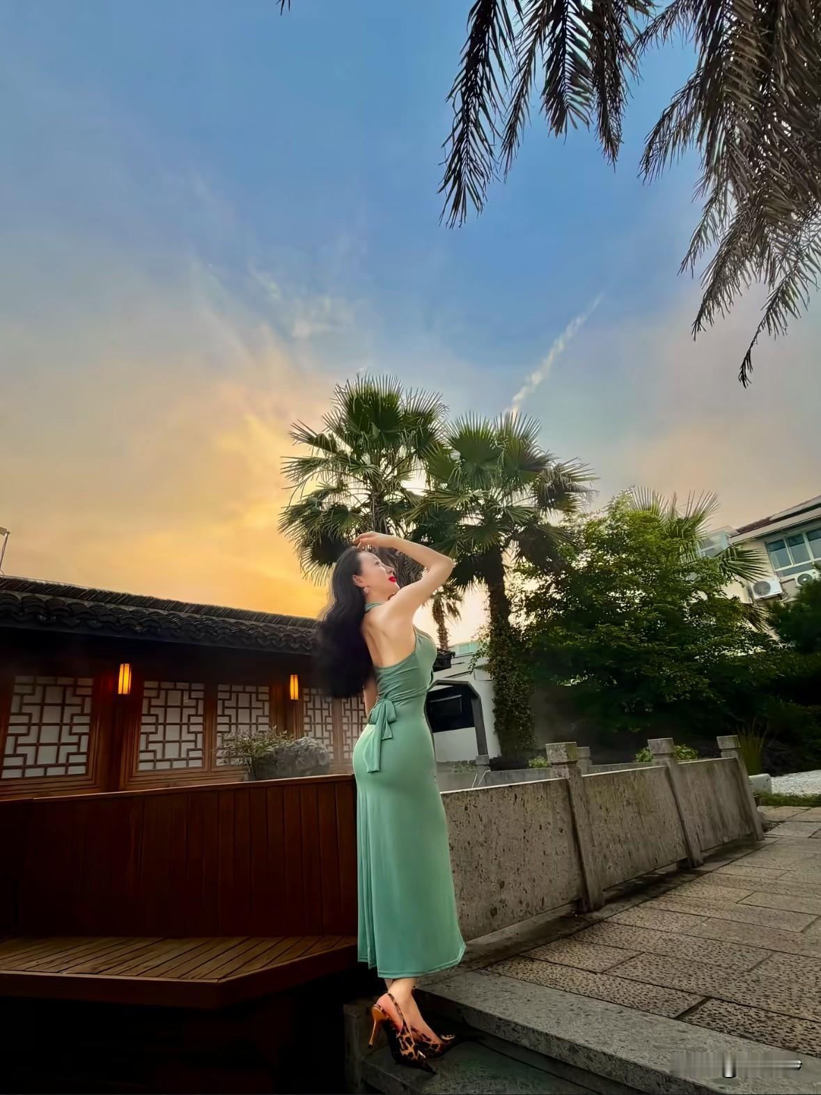 夕阳下的优雅时光，绿裙飘飘，棕榈树旁，享受宁静与美好。