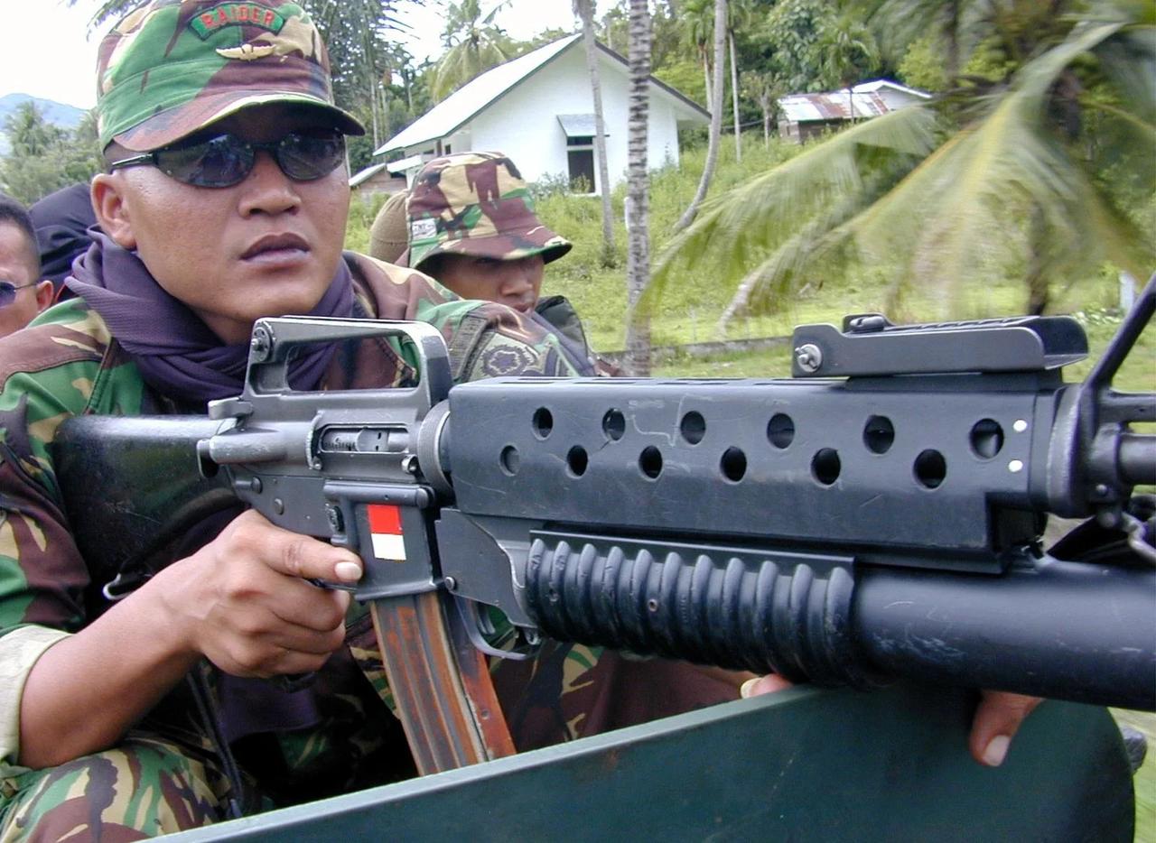 印度尼西亚海军陆战队士兵使用配备 M203 榴弹发射器的 Colt M16A1 