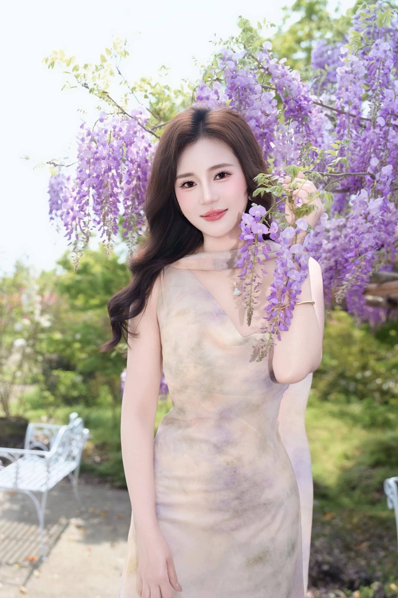 她有着一头乌黑浓密的大波浪长发，发丝柔顺地垂落在肩头，衬得脸型愈发小巧精致。眉眼