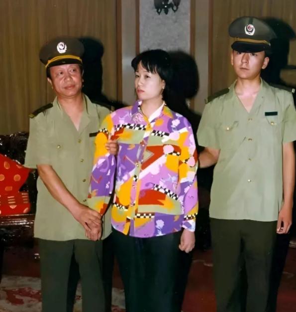 2000年，刘艺霞被判死刑，照片中的她，身穿花衬衫，被两名警察押送着，面无表情，