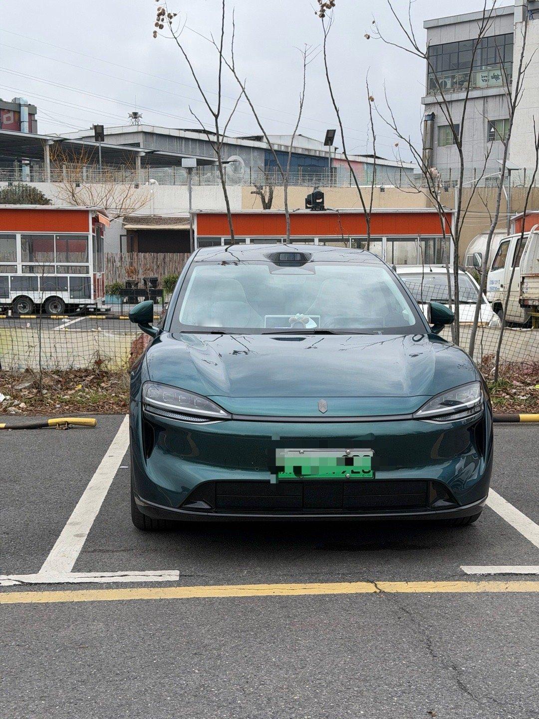 激光绿的车漆在阴天里也自带高级感，低趴的轿跑造型又酷又优雅，停在路边让我忍不住拍