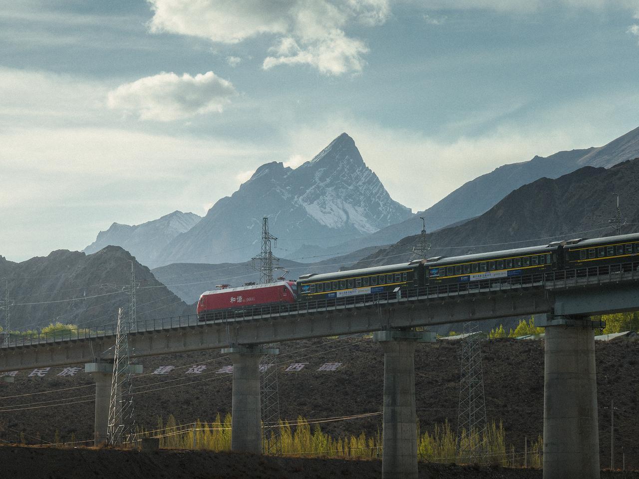 西藏林芝，K6834号列车驶过雅鲁藏布江上的桥梁，背后是藏东地区壮观的雪山🏔