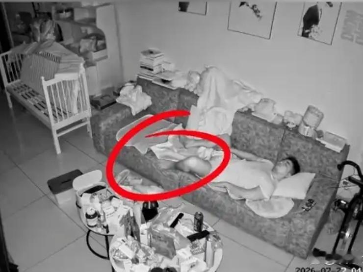 哭笑不得。福建，一男子在家中客厅沙发上睡觉，这家中狗子则在沙发旁边的地上陪着男子