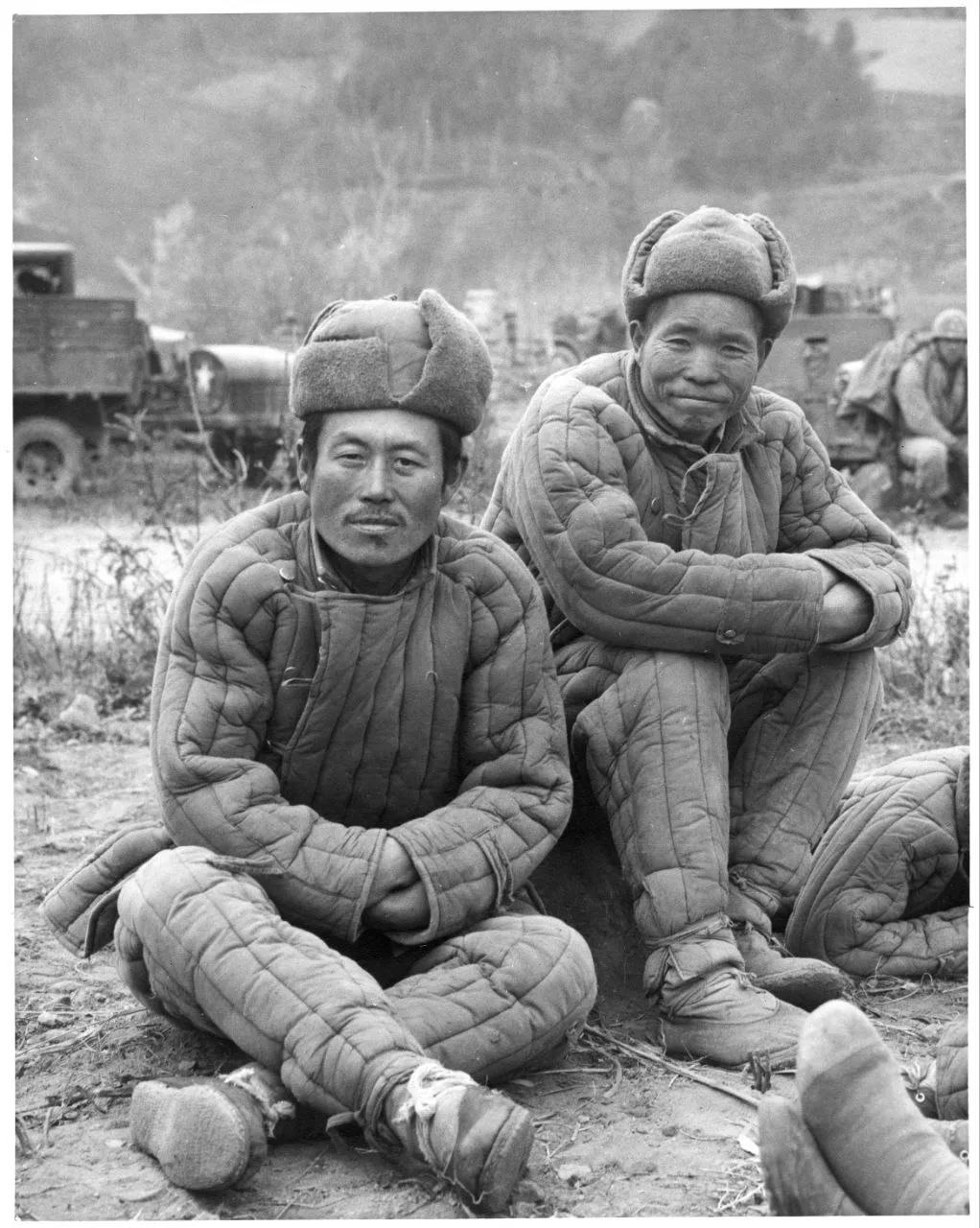 朝鲜战场上被俘的志愿军战士。两人身穿苏式绗缝棉袄，头戴栽绒棉帽，保暖效果不错。但