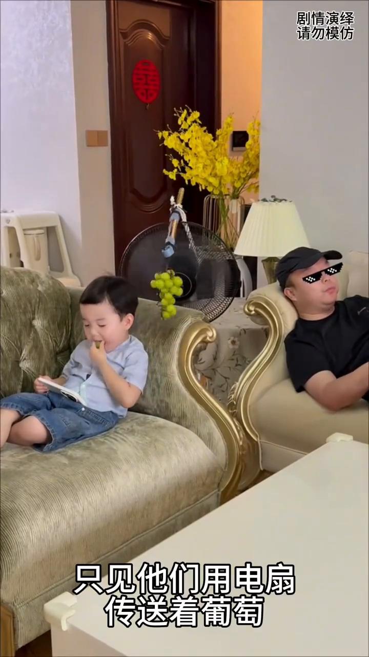 父子两个人躺沙发上吃葡萄，这一幕真的太有才了。
父子两个人躺沙发上吃葡萄，只见他