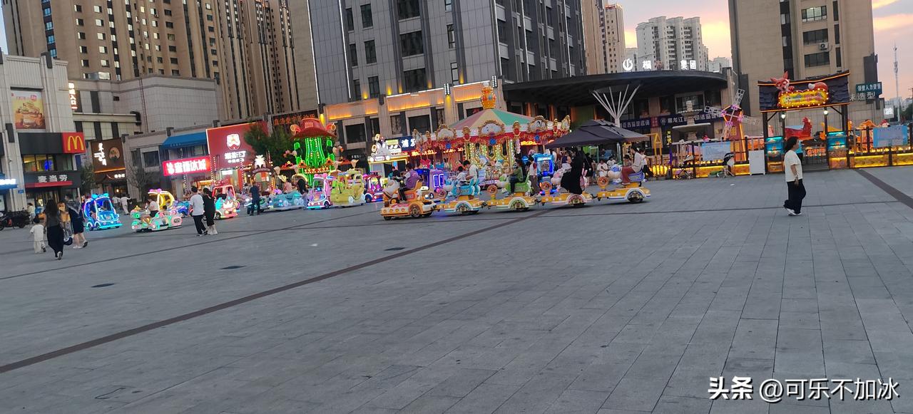 夕阳刚爬上楼顶，广场秒变“儿童游乐场VIP专场”！

旋转木马+发光小火车+迷你