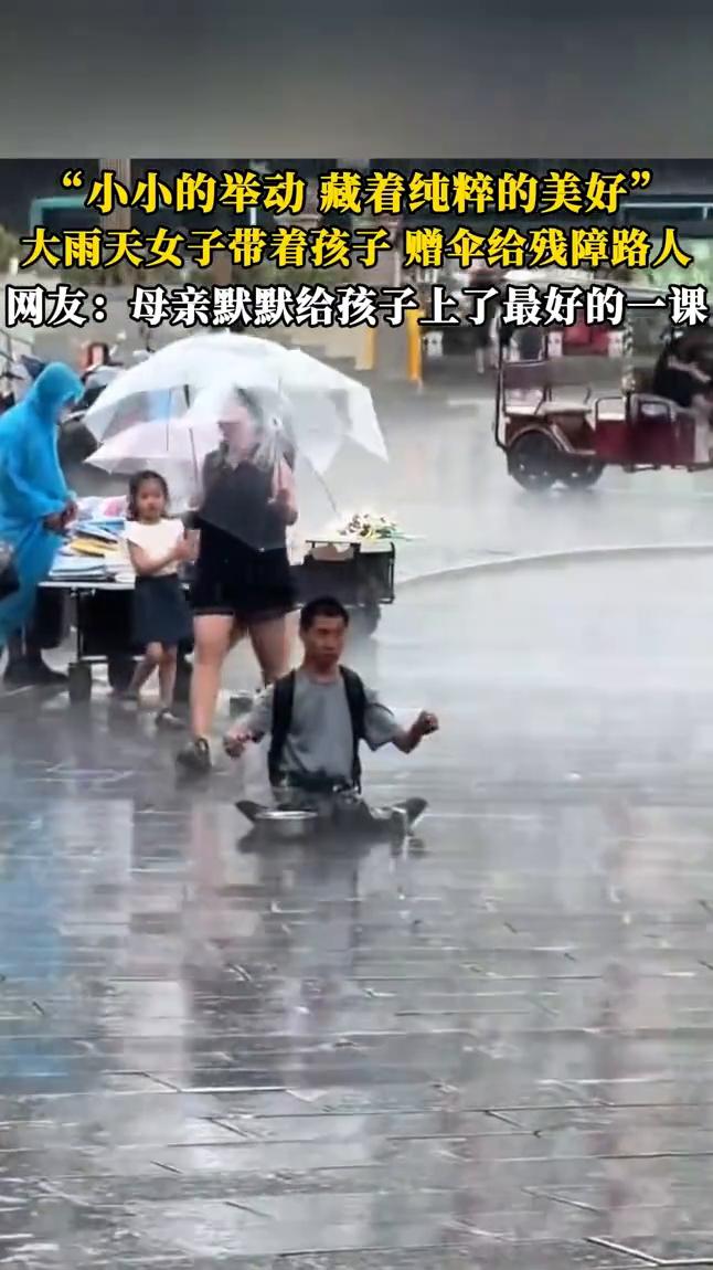 "小小的举动藏着纯粹的美好"。
大雨天女子带着孩子赠伞给残障路人。网友：母亲默默