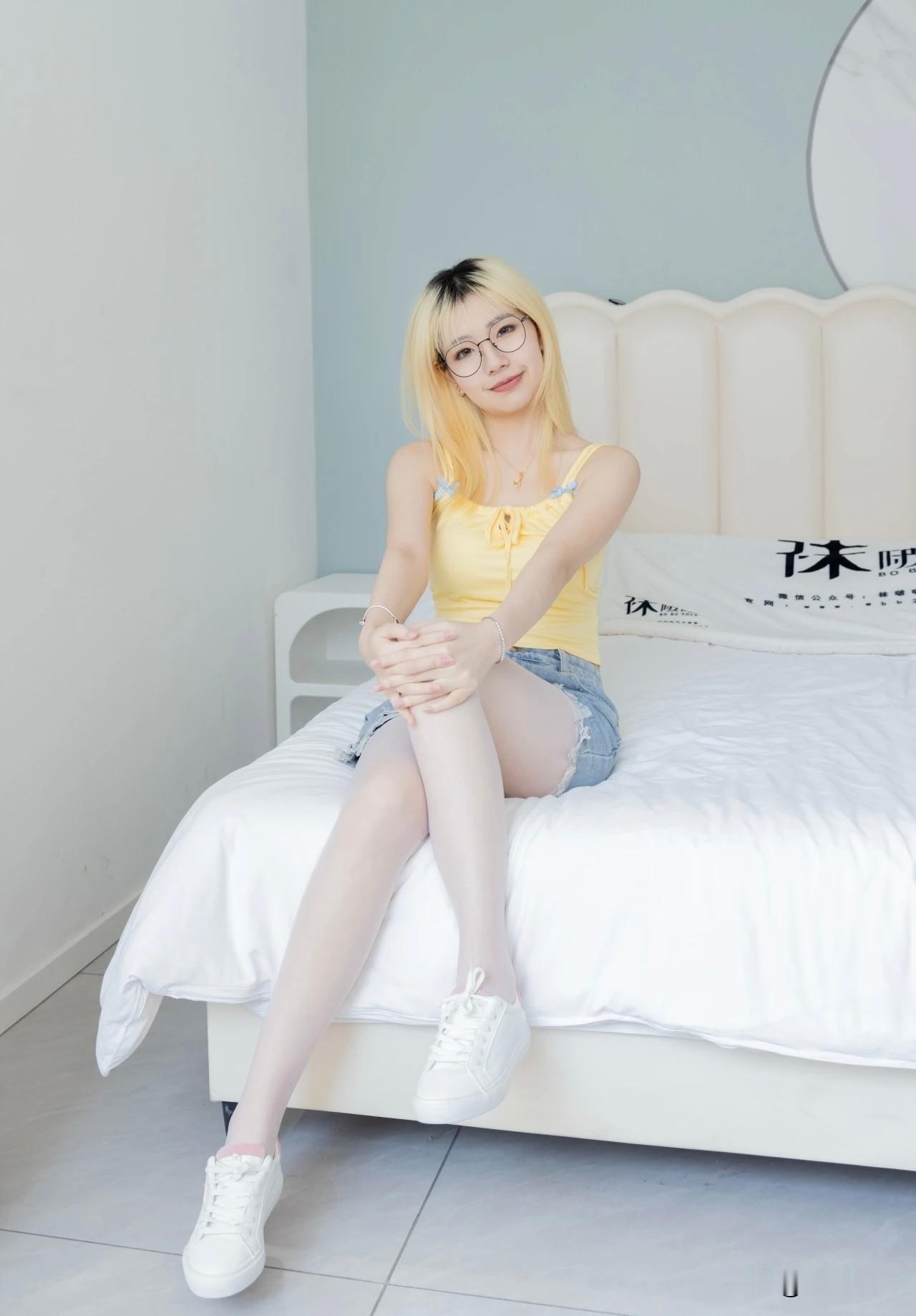 看到一个女孩甜豆坐在床上，穿着黄色背心和牛仔裤，这画面瞬间就有那味儿了。黄色背心