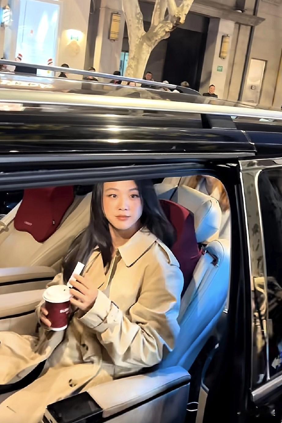 在上海的夜晚街头，偶遇汤唯老师啦！她坐在车内，身着卡其色风衣，手持咖啡和小物件